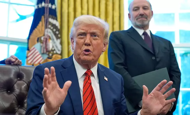 FILE - President Donald Trump speaks as he signs executive orders in the Oval Office of the White House, April 17, 2025, in Washington, as Commerce Secretary Howard Lutnick listens. (AP Photo/Alex Brandon, FIle)
