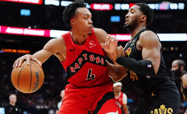 Toronto Raptors' Scottie Barnes (4) protects the ball from Cleveland Cavaliers' Donovan Mitchell (45) during the second half of Game 6 in the first round of an NBA basketball playoffs series in Toronto, Friday, May 1, 2026. (Frank Gunn/The Canadian Press via AP)