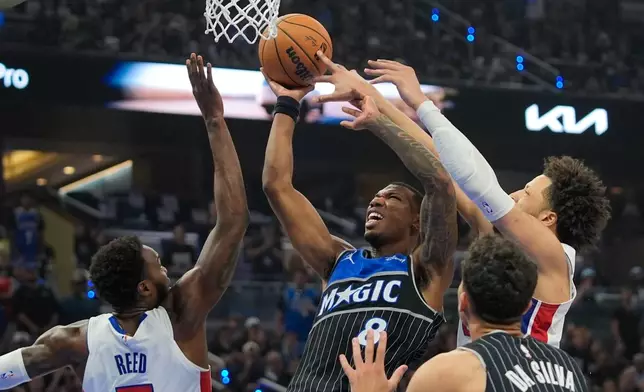 Orlando Magic forward Jamal Cain, center, struggles to get off a shot between Detroit Pistons forward Paul Reed, left, and guard Cade Cunningham during the second half in Game 6 of a first-round NBA basketball playoffs series, Friday, May 1, 2026, in Orlando, Fla. (AP Photo/John Raoux)