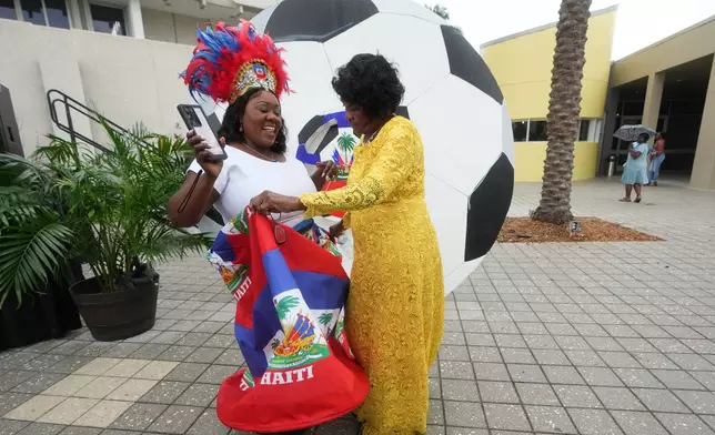 Guensine Ambo, right, dances at a Haitian Heritage Month event featuring the Haiti national soccer team, Saturday, May 30, 2026, in North Miami, Fla., ahead of the FIFA World Cup soccer tournament. (AP Photo/Lynne Sladky)