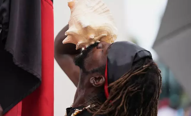 Jeffrey Pluviose blows a conch shell at a Haitian Heritage Month event featuring the Haiti national soccer team, Saturday, May 30, 2026, in North Miami, Fla., ahead of the FIFA World Cup soccer tournament. (AP Photo/Lynne Sladky)
