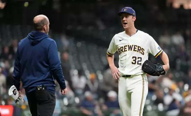 Milwaukee Brewers' Jacob Misiorowski, right, talks with a trainer before the eighth inning of a baseball game against the San Diego Padres, Wednesday, May 13, 2026, in Milwaukee. (AP Photo/Aaron Gash)