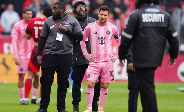 Inter Miami CF midfielder Lionel Messi (10) is surrounded by security on the field after multiple fans ran onto the pitch during second half MLS soccer against Toronto FC, in Toronto on Saturday, May 9, 2026. (Frank Gunn /The Canadian Press via AP)