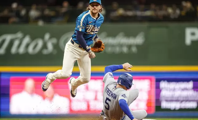 Milwaukee Brewers second baseman Brice Turang (2) forces out Los Angeles Dodgers' Freddie Freeman during the seventh inning of a baseball game, Friday, May 22, 2026, in Milwaukee. (AP Photo/Jeffrey Phelps)