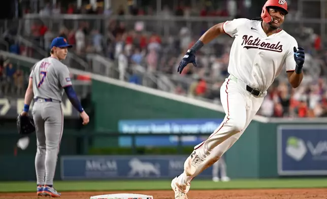 New York Mets third baseman Brett Baty (7) watches Washington Nationals' James Wood head home on a inside-the-park grand slam during the second inning of a baseball game, Tuesday, May 19, 2026, in Washington. (AP Photo/John McDonnell)