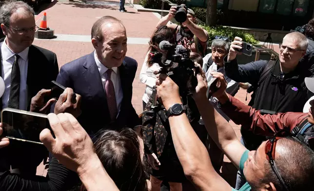 Steven F. Molo, attorney for Elon Musk, second from left, speaks to reporters outside the U.S. District Court, Monday, May 18, 2026, in Oakland, Calif. (AP Photo/Nathan Weyland)