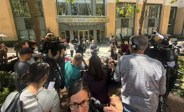 Marc Toberoff, attorney for Elon Musk, is surrounded by media outside the U.S. District Court Monday, May 18, 2026, in Oakland, Calif. (AP Photo/Nathan Weyland)