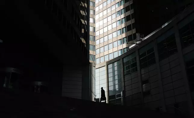 A man approaches the entrance of a bank in Frankfurt, Germany, Monday, May 4, 2026. (AP Photo/Michael Probst)