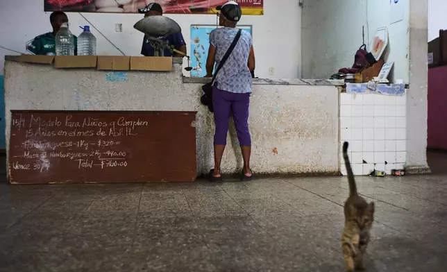 A woman stands at the counter of a state-run bodega in Havana, Cuba, Saturday, May 2, 2026. (AP Photo/Ramon Espinosa)