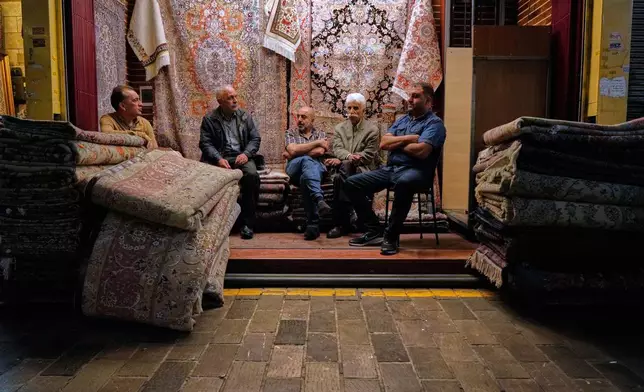 Merchants sit at a carpet shop at the historic Grand Bazaar, in Tehran, Sunday, May 3, 2026. (AP Photo/Vahid Salemi)
