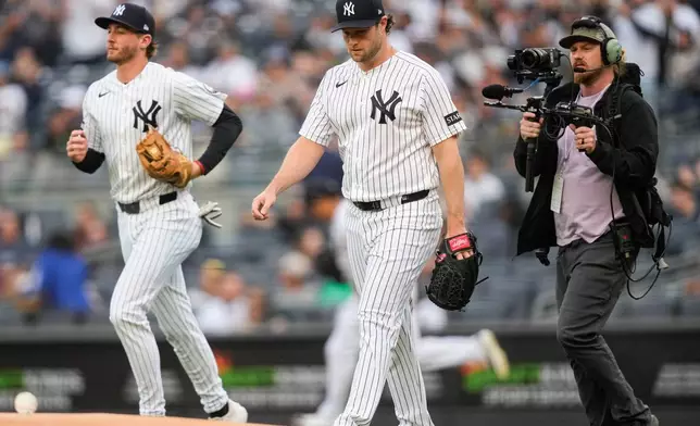 New York Yankees pitcher Gerrit Cole, center, walks to the mound before a baseball game against the Tampa Bay Rays, Friday, May 22, 2026, in New York. (AP Photo/Yuki Iwamura)