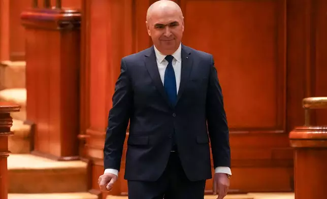 Romanian Prime Minister Ilie Bolojan arrives at a parliament session ahead of a no confidence vote in Bucharest, Romania, Tuesday, May 5, 2026. (AP Photo/Vadim Ghirda)
