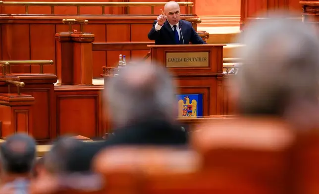 Romanian Prime Minister Ilie Bolojan addresses a parliament session ahead of a no confidence vote in Bucharest, Romania, Tuesday, May 5, 2026. (AP Photo/Vadim Ghirda)