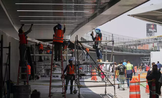 Workers repair the ceiling of the Terminal 1 during a guided media tour of the renovation work at Benito Juárez International Airport, in preparation for the 2026 World Cup in Mexico City, on Tuesday, May 19, 2026. (AP Photo/Fernando Llano)