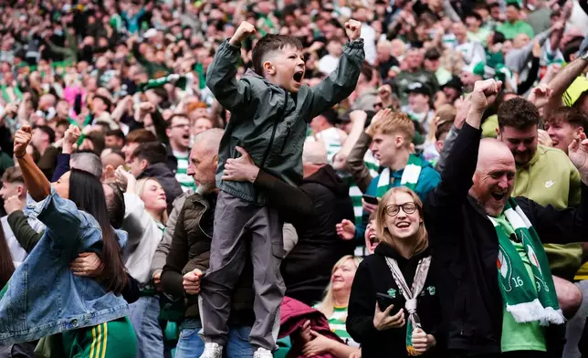 A young Celtic fan celebrates his side's equalising goal during the Premiership soccer match between Celtic and Heart of Midlothian, in Glasgow, Scotland, Saturday May 16, 2026. (Andrew Milligan//PA via AP)