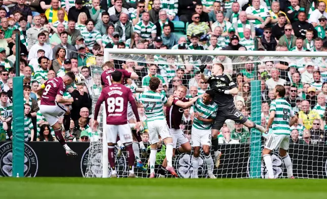 Heart of Midlothian's Lawrence Shankland, left, heads the ball to score the opening goal during the Premiership soccer match between Celtic and Heart of Midlothian, in Glasgow, Scotland, Saturday May 16, 2026. (Andrew Milligan//PA via AP)