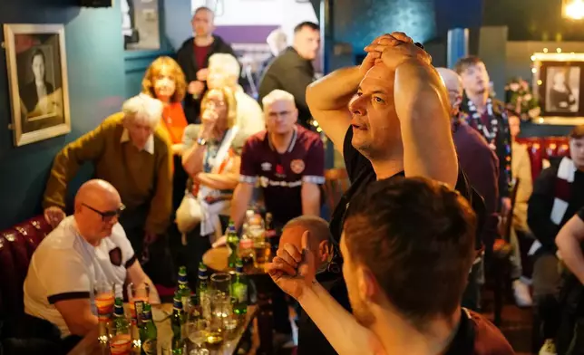 Heart of Midlothian fans show dejection as they watch the Scottish Premier League championship decider against Celtic, at Etore's bar near the stadium in Edinburgh, Scotland, Saturday May 16, 2026. (Jane Barlow/PA via AP)
