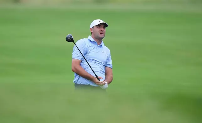 Scottie Scheffler watches his shot on the 14th hole during the first round of the Byron Nelson golf tournament in McKinney, Texas, Thursday, May 21, 2026. (AP Photo/LM Otero)