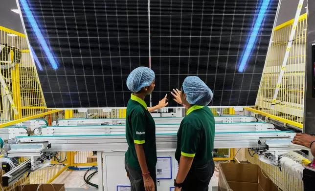 FILE - Workers check the quality of a solar panel at the production line up at the ReNew solar panels manufacturing plant on the outskirts of Jaipur, India, Aug. 21, 2025. (AP Photo/Manish Swarup, File)