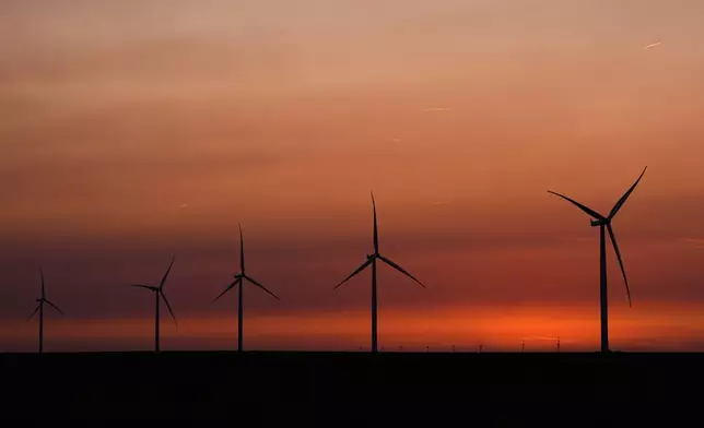 FILE - Wind turbines are silhouetted against the sky at dusk May 15, 2026, near Cimarron, Kan. (AP Photo/Charlie Riedel, File)