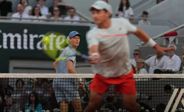 Jannik Sinner of Italy, left, looks as Clement Tabur of France returns during their first round men's singles tennis match at the French Open tennis tournament in Paris, Tuesday, May 26, 2026. (AP Photo/Thibault Camus)