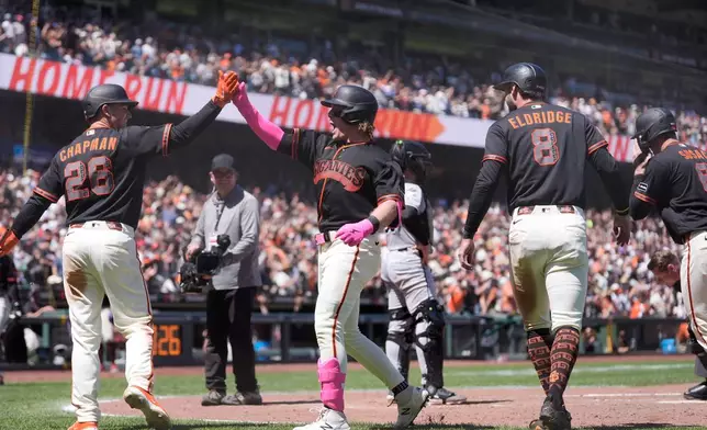 San Francisco Giants' Harrison Bader, middle, celebrates after hitting a grand slam that also scored Matt Chapman (26), Bryce Eldridge (8) and Daniel Susac, right, during the fifth inning of a baseball game against the Chicago White Sox Saturday, May 23, 2026, in San Francisco. (AP Photo/Jeff Chiu)