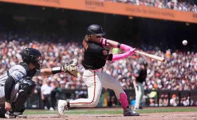 San Francisco Giants' Harrison Bader, right, hits a grand slam next to Chicago White Sox catcher Drew Romo during the fifth inning of a baseball game Saturday, May 23, 2026, in San Francisco. (AP Photo/Jeff Chiu)