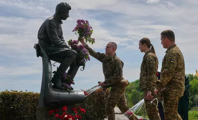 Ukrainian army officers lay flowers at a monument to pilots to mark Victory Day in World War II, in Kyiv, Ukraine, Friday, May 8, 2026, as the Russian attack on Ukraine continues. (AP Photo/Efrem Lukatsky)