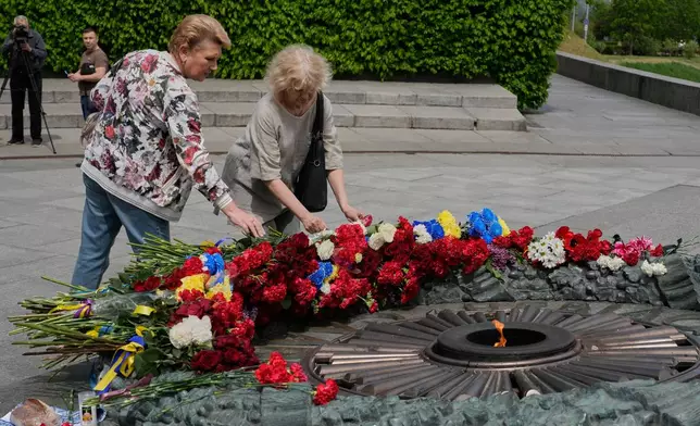 People lays flowers to the monument of the Unknown Soldier to mark Victory Day in World War II, in Kyiv, Ukraine, Tuesday, May 8, 2026. (AP Photo/Efrem Lukatsky)