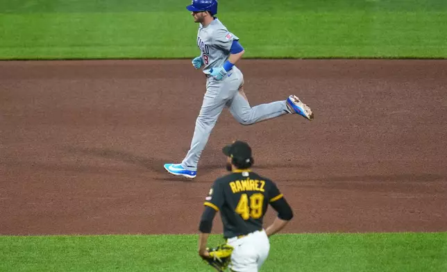 Chicago Cubs' Ian Happ, top, rounds the bases after hitting a three-run home run off Pittsburgh Pirates pitcher Yohan Ramírez (49) during the seventh inning of a baseball game in Pittsburgh, Wednesday, May 27, 2026. (AP Photo/Gene J. Puskar)