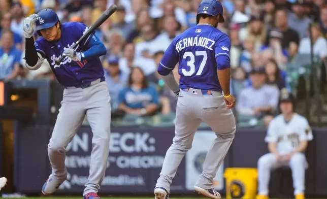 Los Angeles Dodgers' Teoscar Hernández (37) scores on a wild pitch as Shohei Ohtani, left, reacts during the fourth inning of a baseball game against the Milwaukee Brewers, Sunday, May 24, 2026, in Milwaukee. (AP Photo/Kayla Wolf)