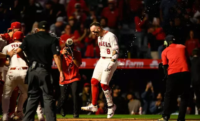 Los Angeles Angels' Zach Neto (9) is greeted by teammates after hitting a walk0ff home run during the ninth inning of a baseball game against the Athletics, Monday, May 18, 2026, in Anaheim, Calif. (AP Photo/William Liang)
