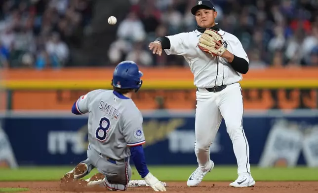 Detroit Tigers second baseman Hao-Yu Lee throws to first base to complete a double play as Texas Rangers' Josh Smith (8) slides late into second base during the fifth inning of a baseball game Saturday, May 2, 2026, in Detroit. (AP Photo/Paul Sancya)
