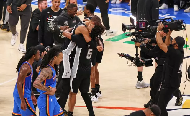 San Antonio Spurs forward Victor Wembanyama and guard Stephon Castle (5) celebrate after defeating the Oklahoma City Thunder in Game 7 of the Western Conference finals of the NBA basketball playoffs series Saturday, May 30, 2026, in Oklahoma City. (AP Photo/Nate Billings)