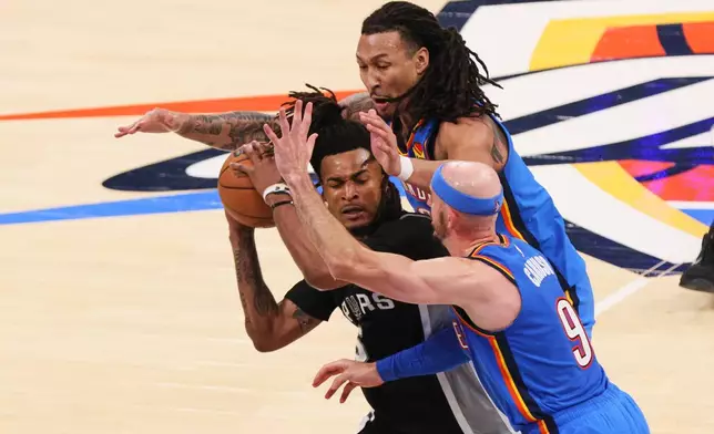 San Antonio Spurs guard Stephon Castle (5) is covered by Oklahoma City Thunder guard Alex Caruso (9) and forward Jaylin Williams in the second half of Game 7 of the Western Conference finals of the NBA basketball playoffs series Saturday, May 30, 2026, in Oklahoma City. (AP Photo/Nate Billings)