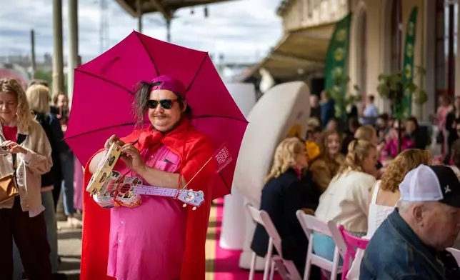 Visitors take part in the Pink Soup Fest celebration on a railway station platform in Vilnius, Lithuania, Friday, May 29, 2026. (AP Photo/Mindaugas Kulbis)