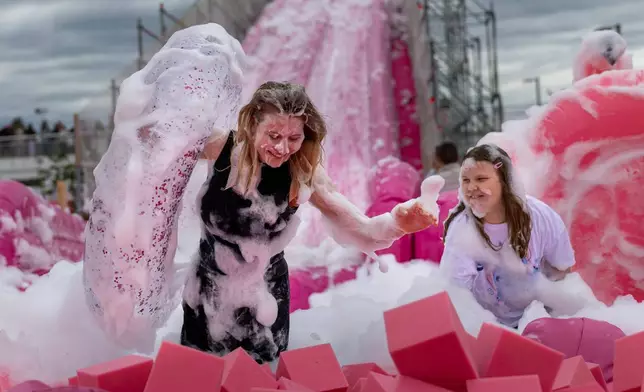 Visitors take part in the Pink Soup Fest festival celebration in Vilnius, Lithuania, Saturday, May 30, 2026. (AP Photo/Mindaugas Kulbis)