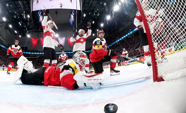 Switzerland's Nico Hischier, right, scores the fifth goal to Austria's goaltender David Kickert, left, during the 2026 IIHF Men's Ice Hockey World Championship preliminary round group A game between Austria and Switzerland, in Zurich, Switzerland, Wednesday, May 20, 2026. (Claudio Thoma/Keystone via AP)
