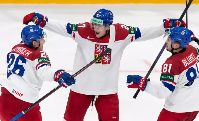 Czechia's Marek Alscher, center, celebrates with Matej Blumel, right, and Jiri Tichacek, left, after scoring during a Group B preliminary round game between the Czech Republic and Italy in Fribourg, Switzerland, Wednesday, May 20, 2026. (Cyril Zingaro/Keystone via AP)