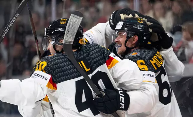 Germany's Marc Michaelis, right, celebrates with teammates after scoring their third goal during a Group A preliminary round game between the United States and Germany at the men's ice hockey world championship in Zurich, Switzerland, Wednesday, May 20, 2026. (Andreas Becker/Keystone via AP)