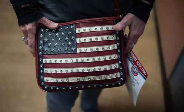 Marylou Zschach holds her American Flag purse after voting at her polling place at the Burbank Early Childhood School in Columbus, Ohio, Tuesday, May 5, 2026, during the primary election. (AP Photo/Carolyn Kaster)