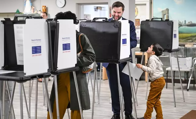 Vice President JD Vance, alongside his son Vivek, votes at a polling location at St. Anthony of Padua Maronite Catholic Church in the state's primary election, Tuesday, May 5, 2026, in Cincinnati, Ohio. Vance is stopping in Ohio to vote in the state's primary election before continuing on to Oklahoma and Iowa. (Roberto Schmidt /Pool Photo via AP)