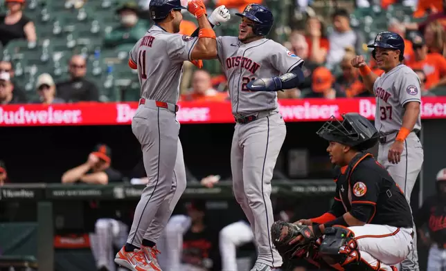 Houston Astros' Cam Smith (11) celebrates with Yainer Diaz (21) after hitting a three-run home run during the first inning in the second baseball game of a doubleheader against the Baltimore Orioles, Thursday, April 30, 2026, in Baltimore. (AP Photo/Stephanie Scarbrough)