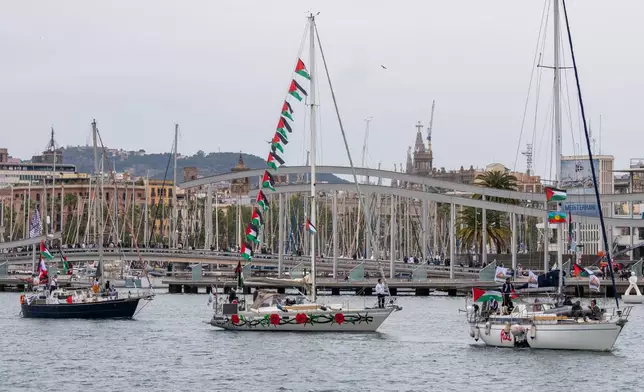 Boats carrying activists and humanitarian aid for Palestinians in Gaza reposition in the port during a symbolic send-off as part of the Global Sumud Flotilla, in Barcelona, Spain, Sunday, April 12, 2026. (AP Photo/Joan Mateu Parra)
