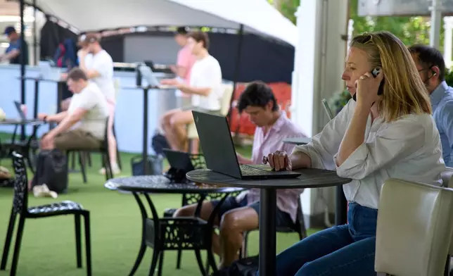 People work on their laptops during a Surrey against Sussex County Championship cricket match at the Kia Oval in London, Friday, May 1, 2026. (AP Photo/Tony Hicks)