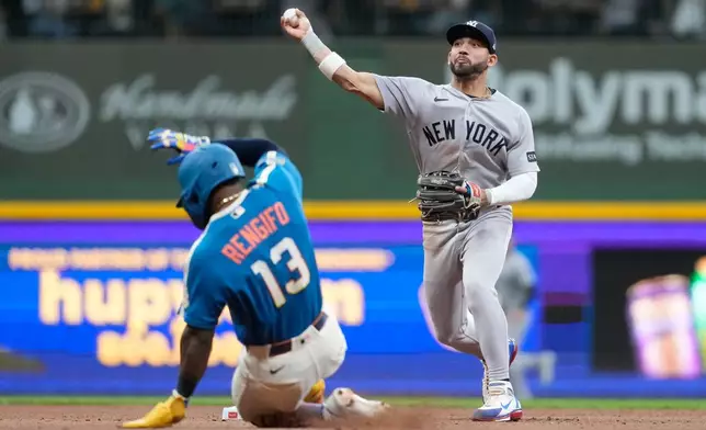 New York Yankees' José Caballero, right, throws to first base to turn a double play after tagging Milwaukee Brewers' Luis Rengifo (13) out at second base during the seventh inning of a baseball game, Friday, May 8, 2026, in Milwaukee. (AP Photo/Aaron Gash)