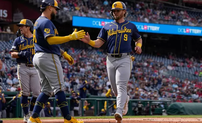 Milwaukee Brewers' Gary Sánchez, left, celebrates with Jake Bauers (9) after they scored on a single hit by Brandon Lockridge during the first inning of a baseball game against the Washington Nationals, Saturday, May 2, 2026, in Washington. (AP Photo/Jess Rapfogel)