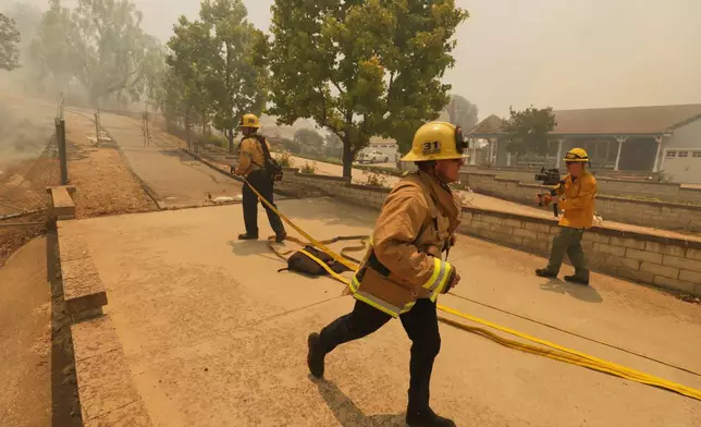 Fire crews battle the Sandy Fire Monday, May 18, 2026, in Simi Valley, Calif. (AP Photo/Ethan Swope)