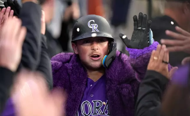 Colorado Rockies' Hunter Goodman is congratulated by teammates in the dugout after hitting a solo home run during the second inning of a baseball game against the Los Angeles Dodgers, Tuesday, May 26, 2026, in Los Angeles. (AP Photo/Mark J. Terrill)