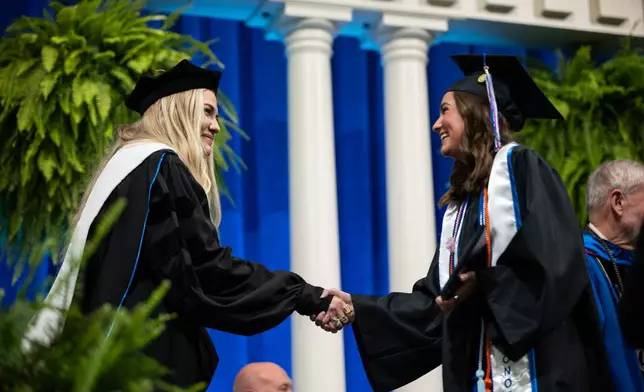 Kirk shaking hands with graduate.